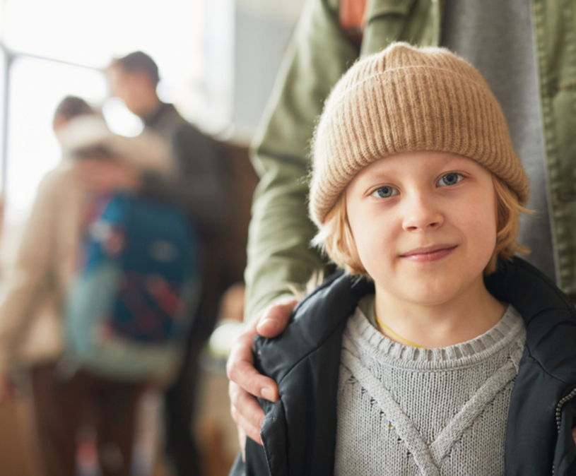 vader staat achter zijn zoon en heeft zijn handen op zijn schouders